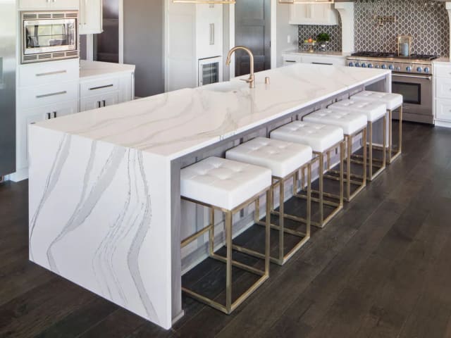 Cambria Brittanicca quartz waterfall island in a bright white kitchen