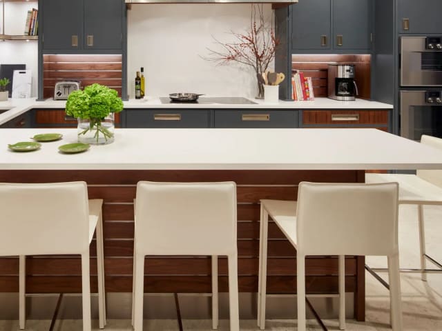 Cambria White Cliff quartz island in a kitchen with dark cabinets