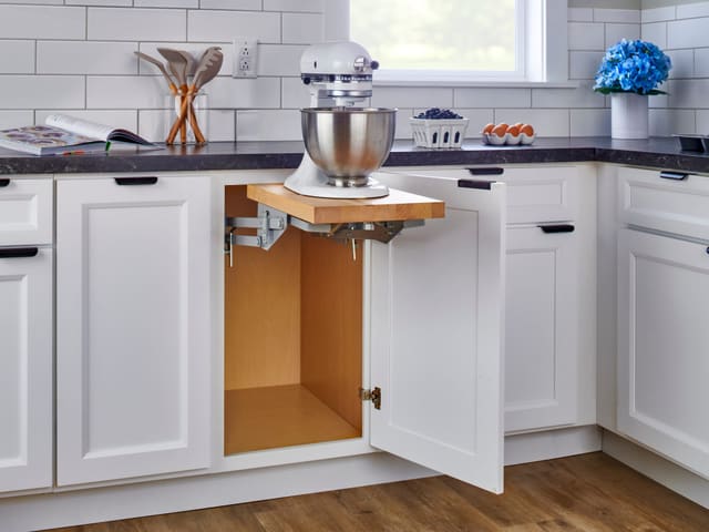 Stand mixer raised out of a base cabinet on a mixer lift